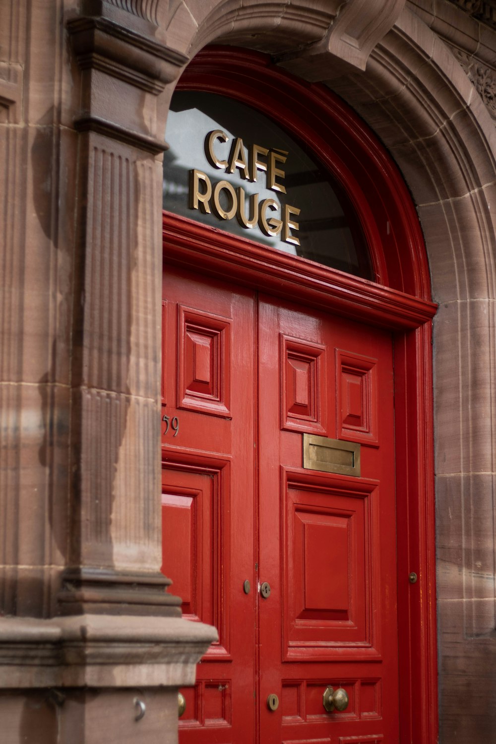 a red door with a sign that says cafe roue