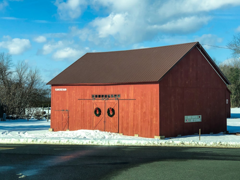 red wooden barn under white clouds and blue sky during daytime