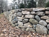 A small decorative dry stone wall bordering a flower bed.