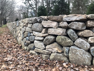 A small decorative dry stone wall bordering a flower bed.