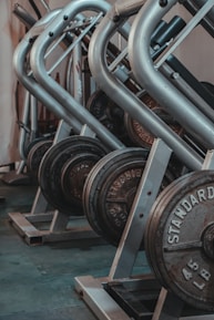 black and gray dumbbells on brown wooden rack