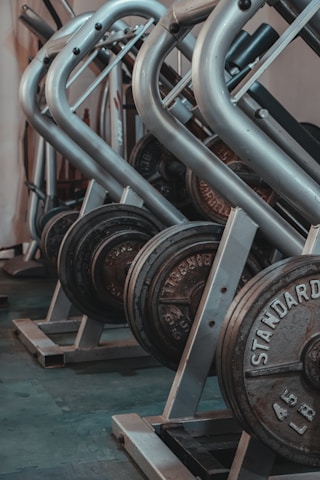 black and gray dumbbells on brown wooden rack
