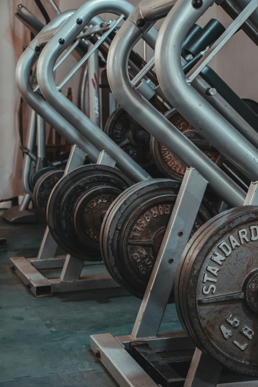 black and gray dumbbells on brown wooden rack