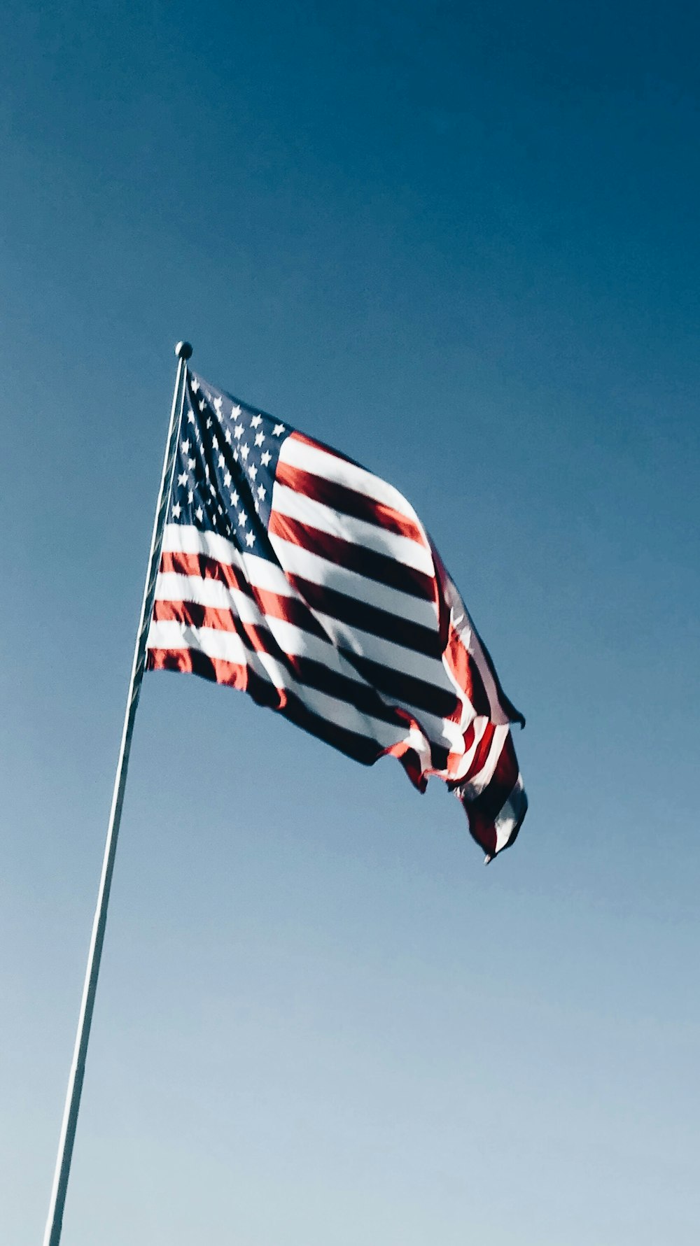 미국 낮 동안 푸른 하늘 아래 기둥에 깃발