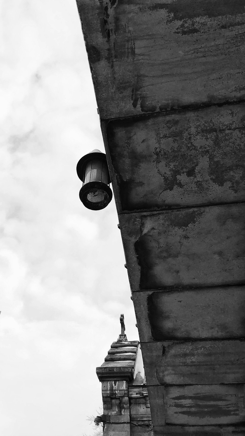 Foto in scala di grigi della lampadina sul muro di cemento