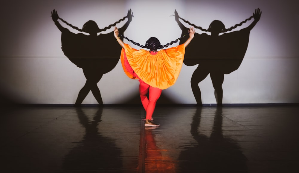 woman in yellow dress dancing on brown wooden floor