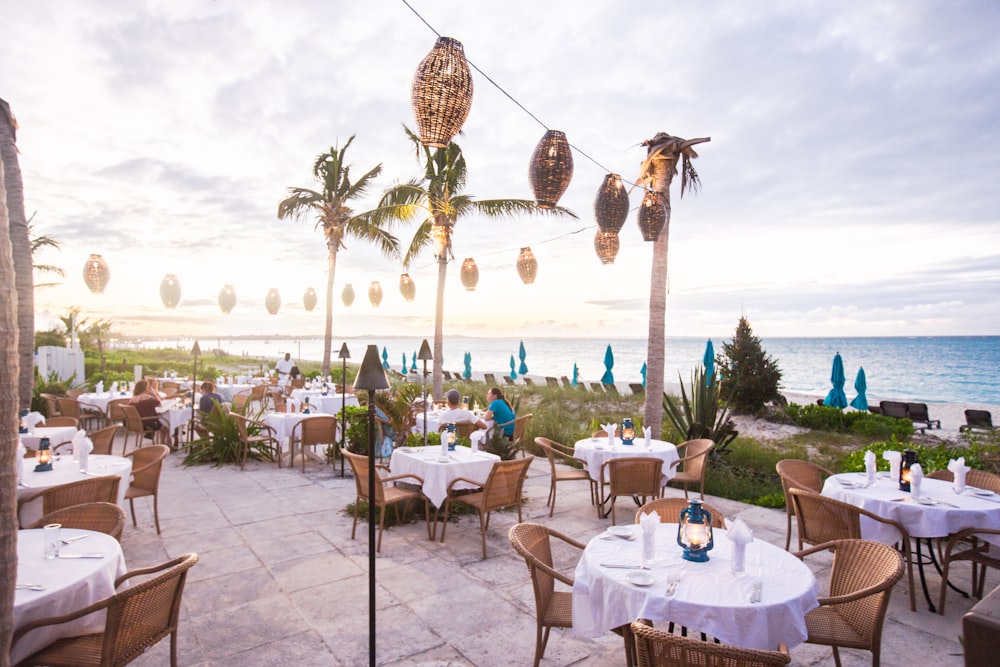 white table and chairs near green palm tree during daytime