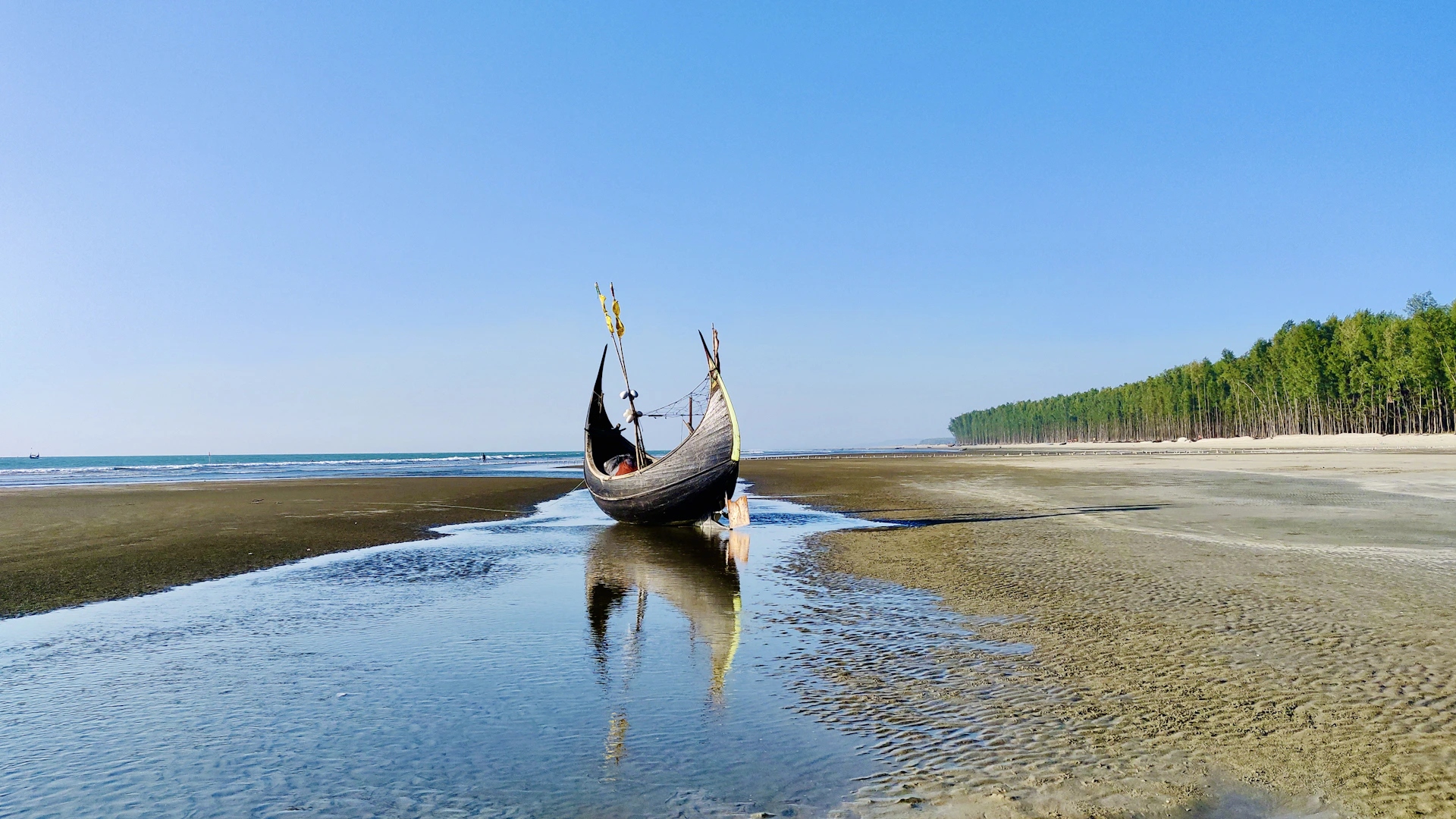 black boat on sea shore during daytime