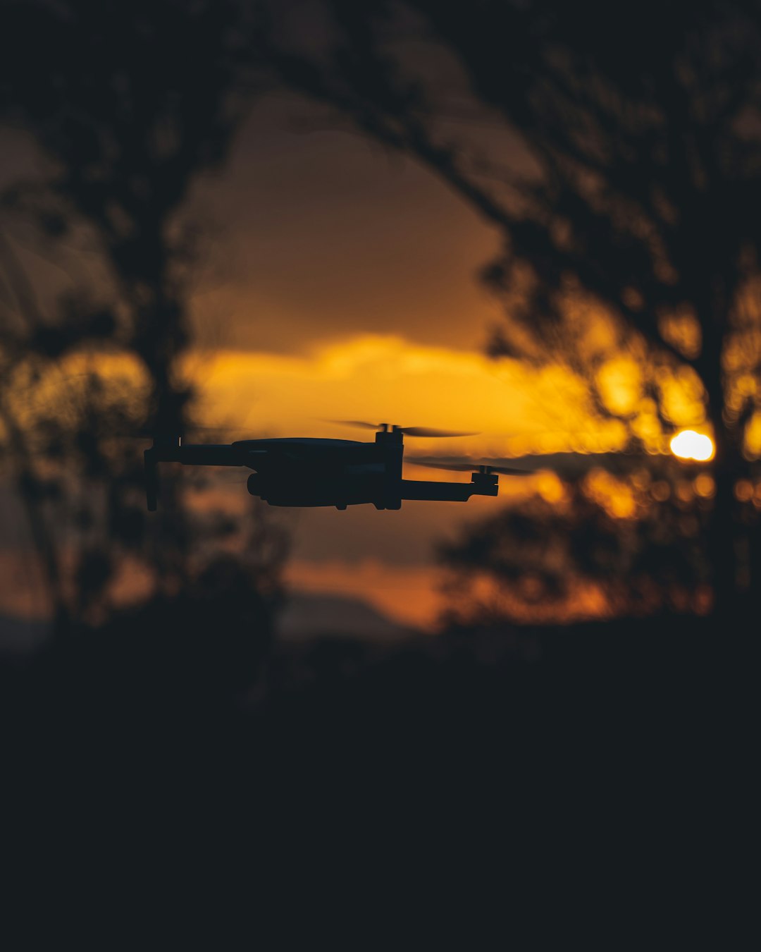black and white drone flying during sunset