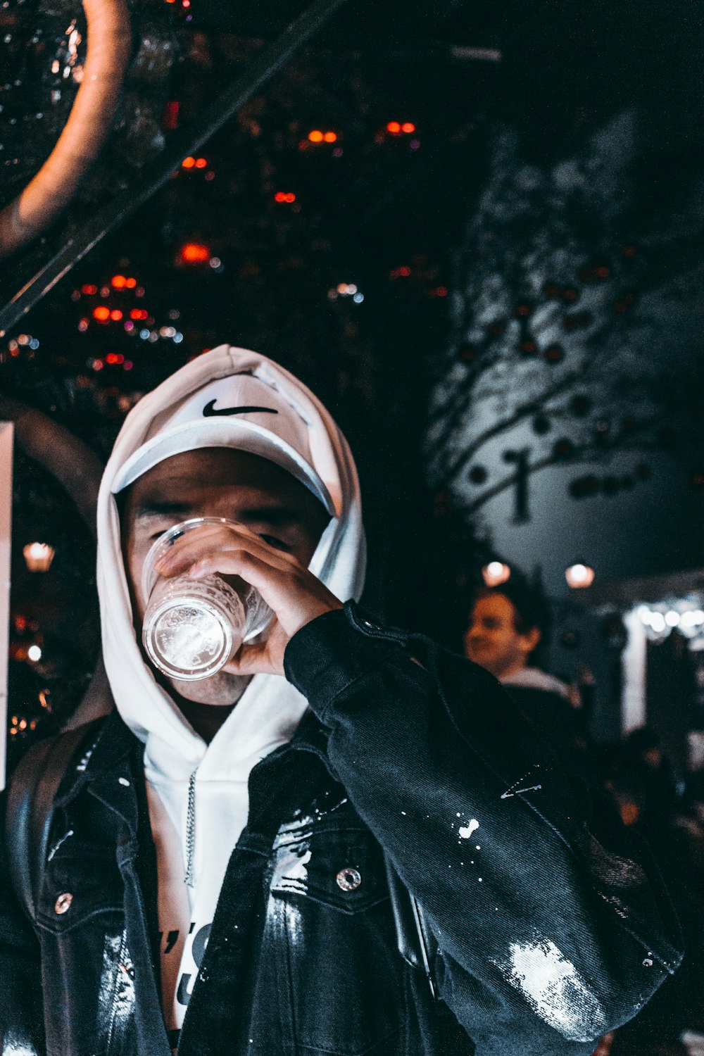 person in black leather jacket drinking water