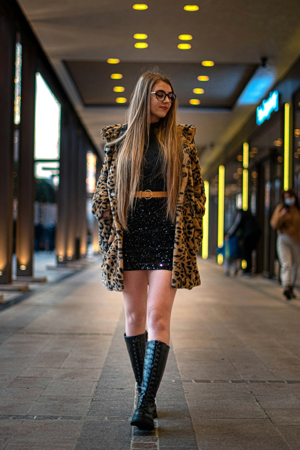 Foto mujer con abrigo de leopardo marrón y botas de cuero negro caminando  por la acera durante el día – Imagen Timisoara gratis en Unsplash