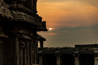 A panoramic view of the Sun Temple at Konark bathed in golden sunset light, with intricate stone carvings glowing warmly.