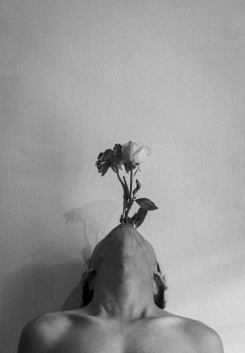 grayscale photo of man holding flower