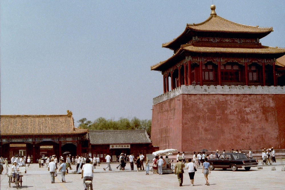 people walking on street near brown and red concrete building during daytime