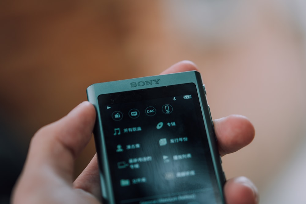 person holding white and black sony xperia