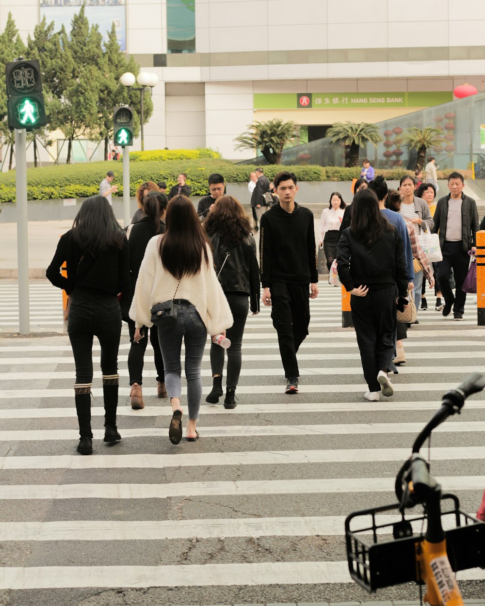 woman in black coat walking on pedestrian lane