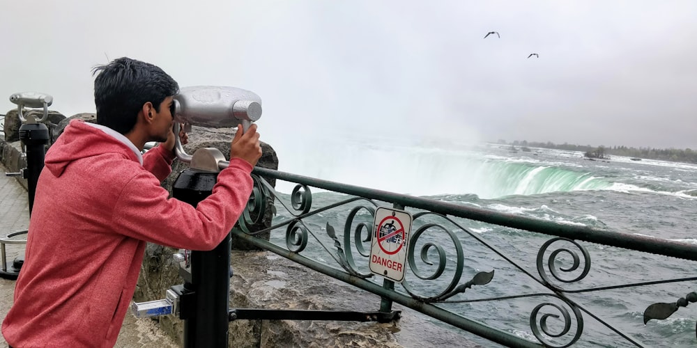 person in red jacket holding gray camera