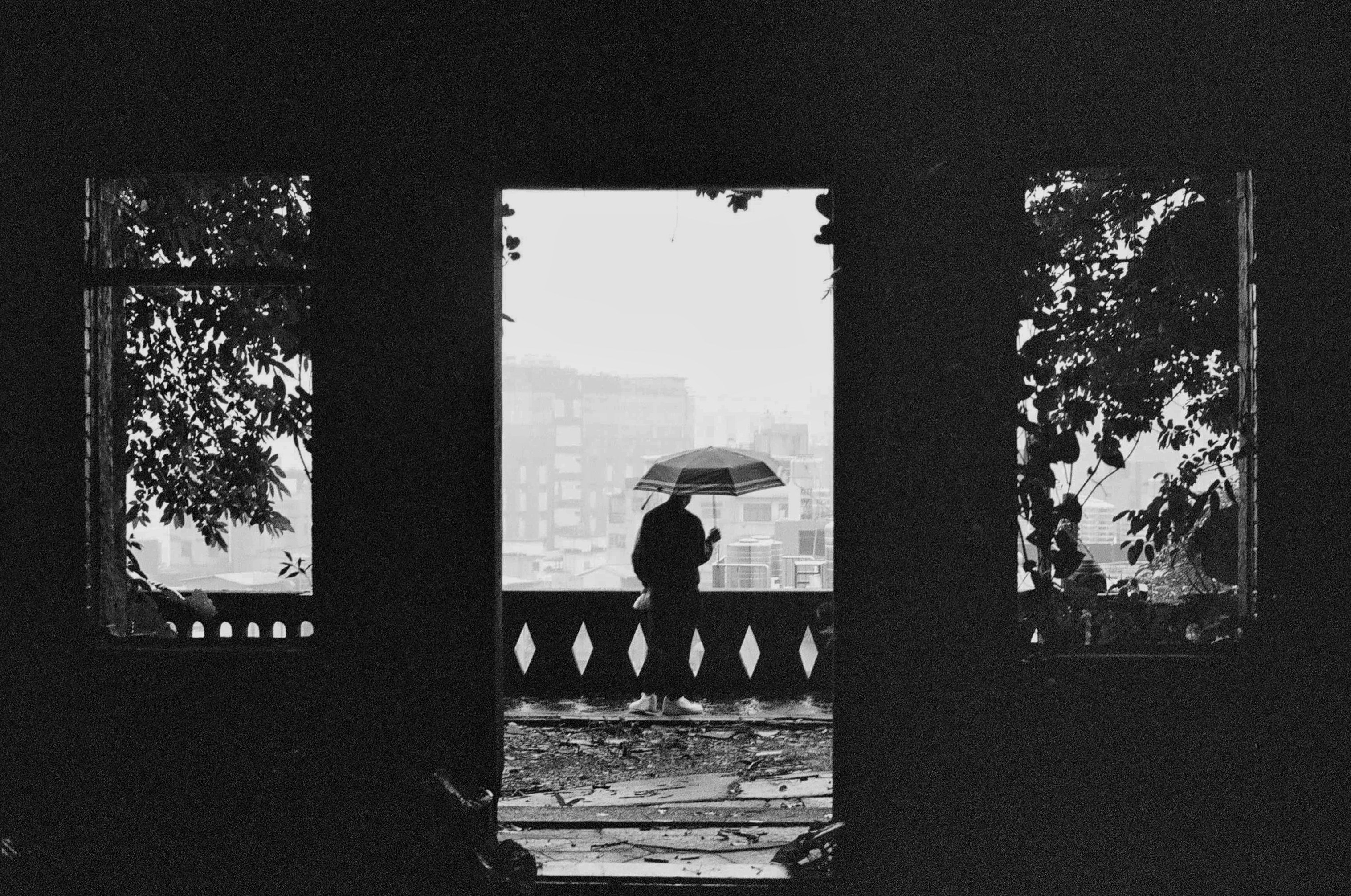 foto em tons de cinza da pessoa que segura o guarda-chuva