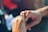 Close-up of hands exchanging house keys over a real estate contract on a wooden table.
