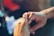 A close-up of hands exchanging wedding rings with a soft-focus background.