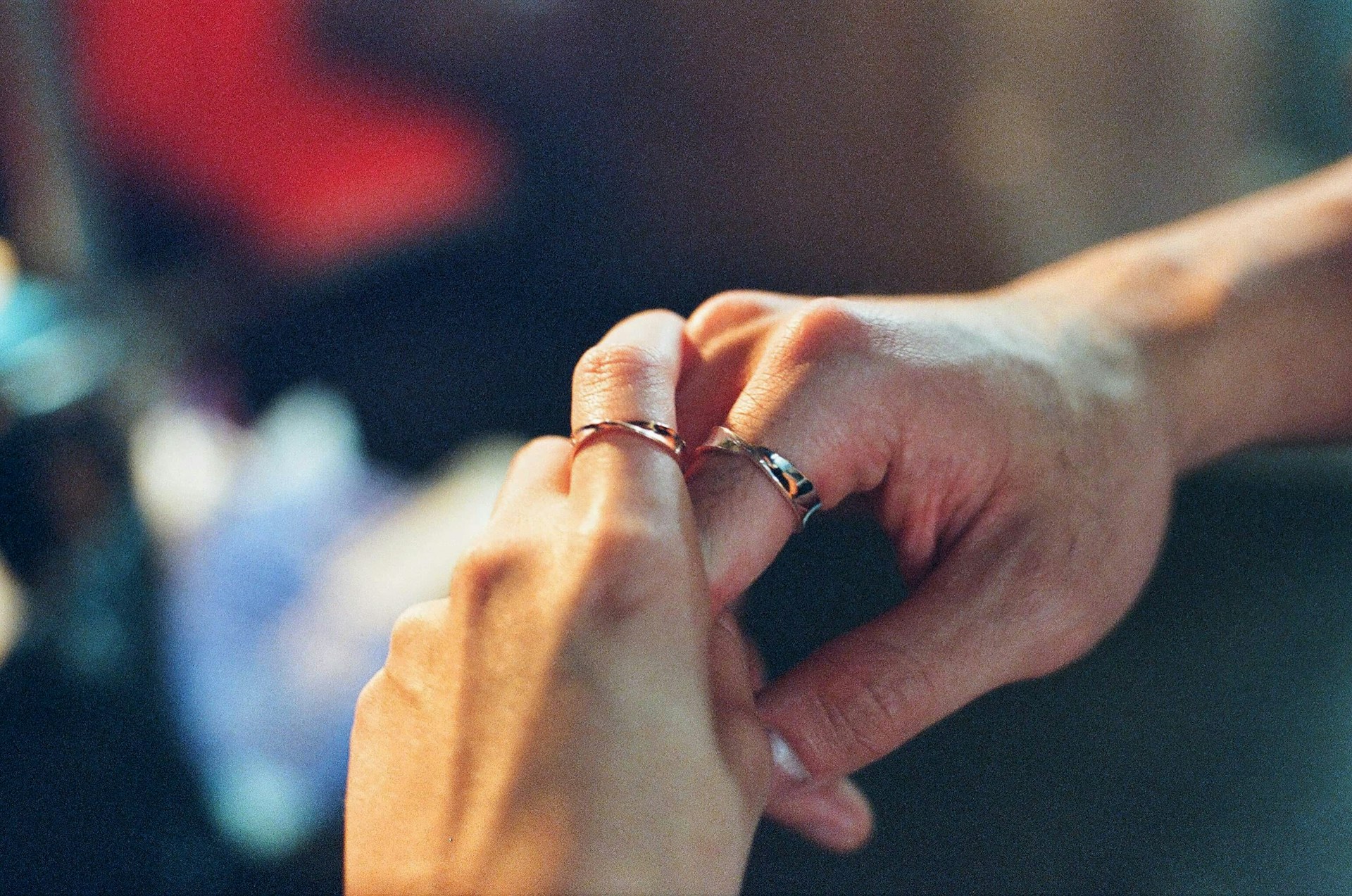 An intimate close-up of intertwined hands with wedding rings, capturing the emotion of the day.
