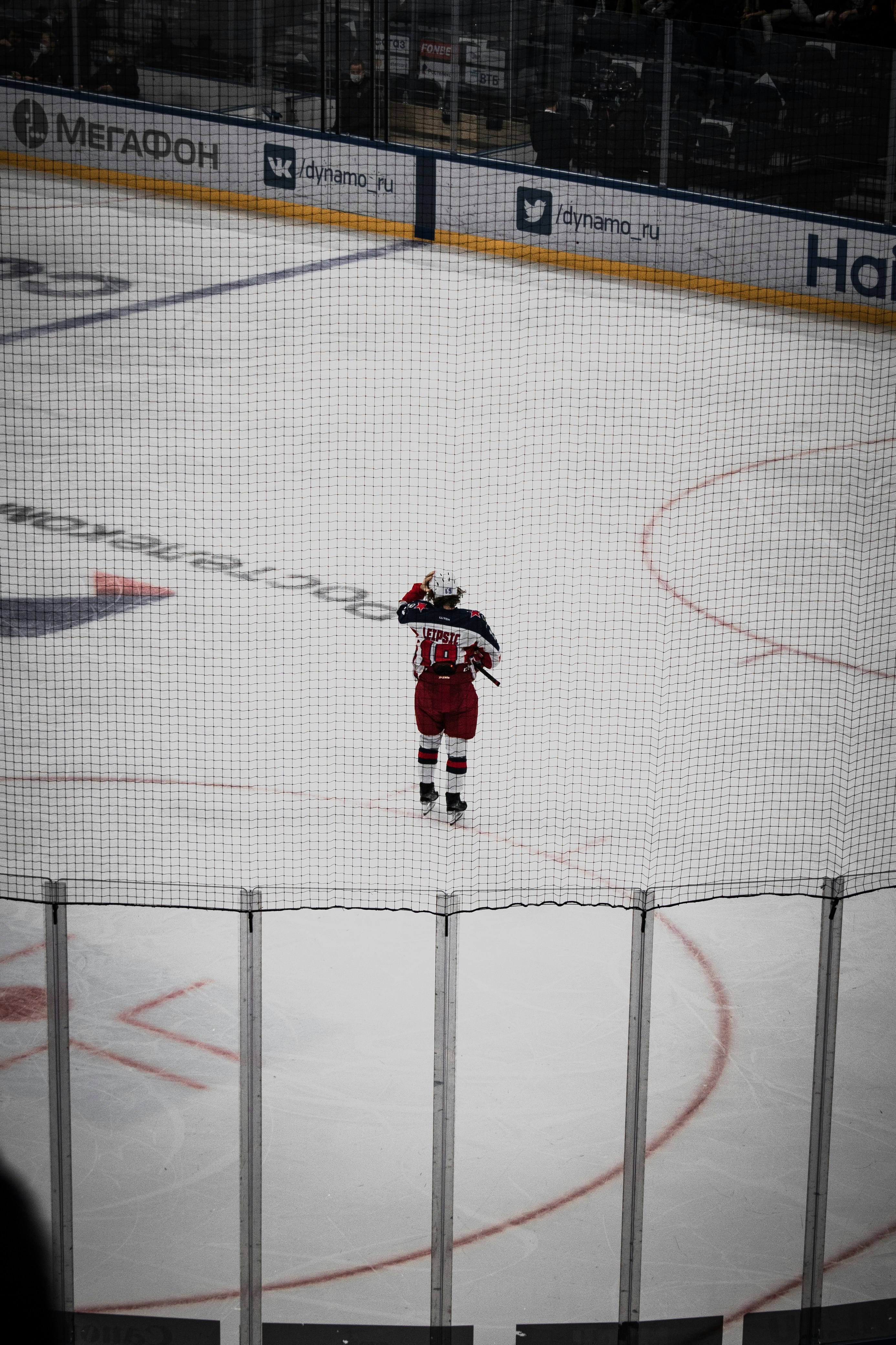 man in black and red jacket and black pants playing hockey