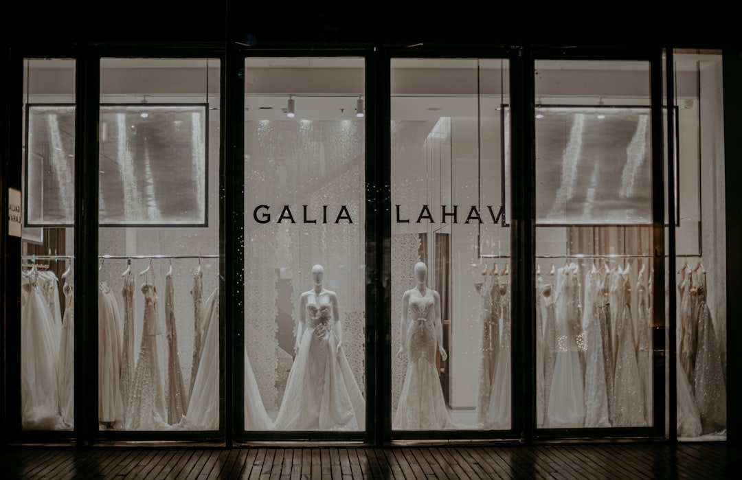 woman in white dress standing beside glass window