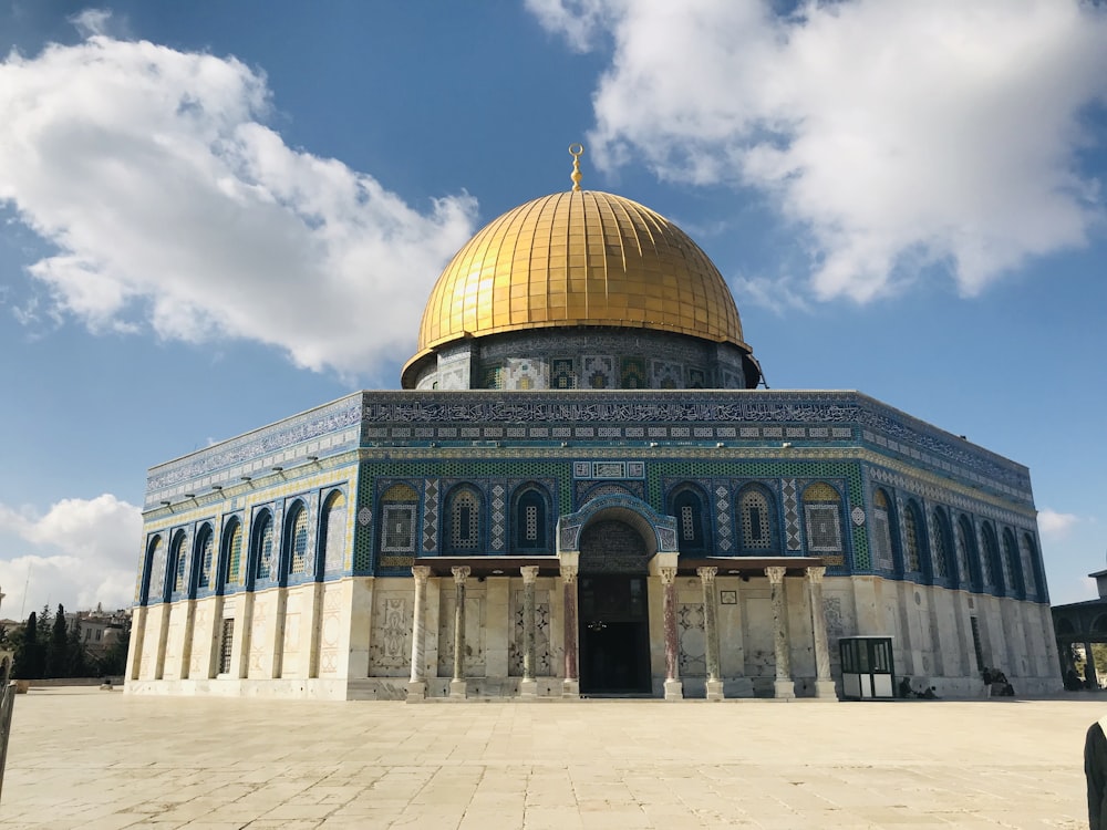 green and white dome building under blue sky and white clouds during daytime