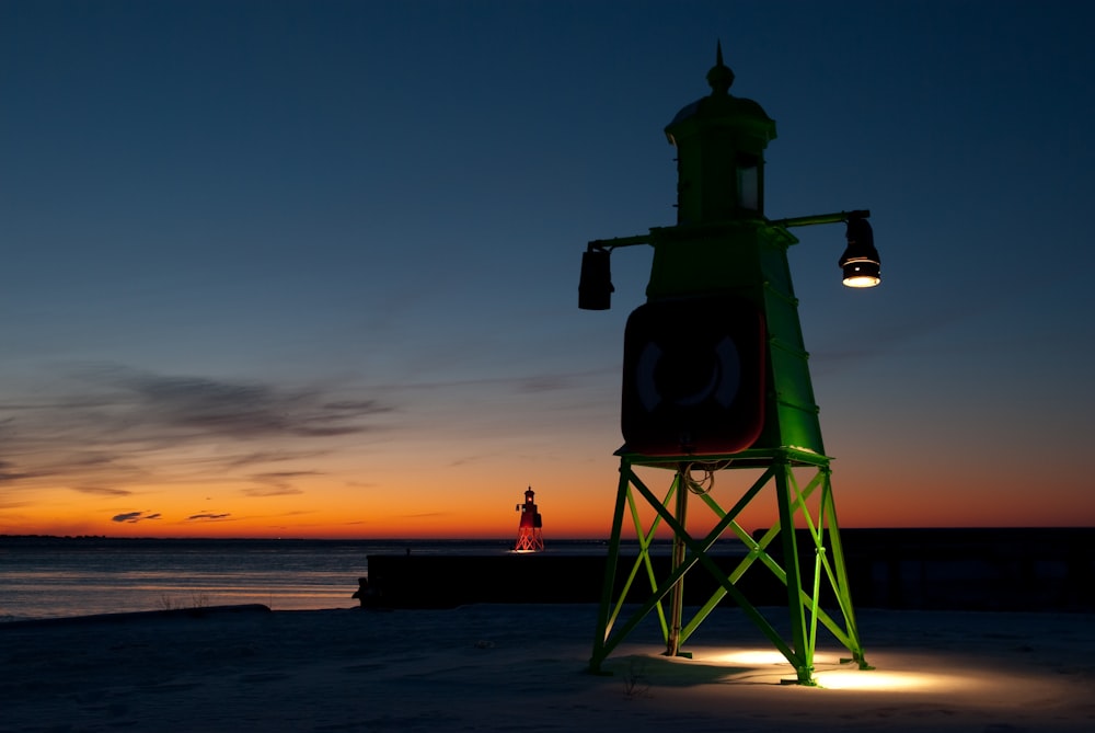 silhouette of person standing on tower during sunset