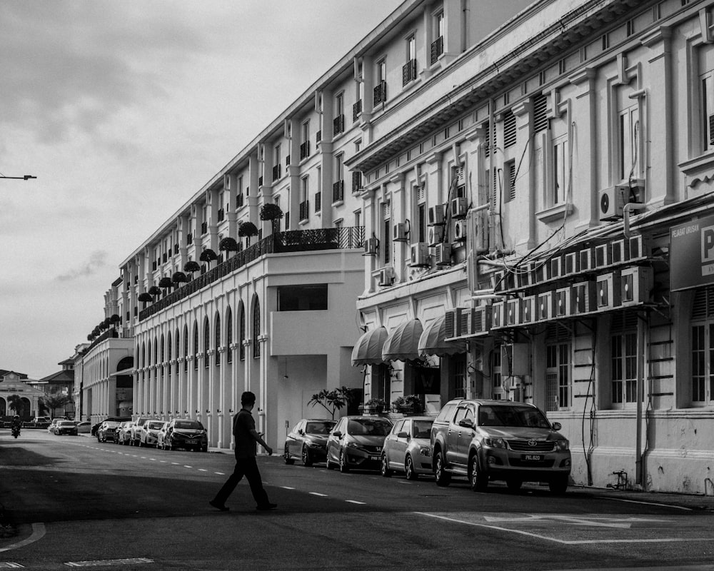 grayscale photo of cars parked in front of building