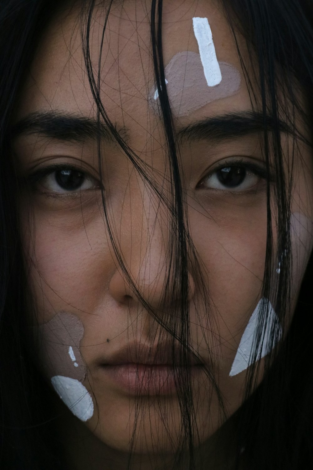 woman with brown hair and white plastic eye mask