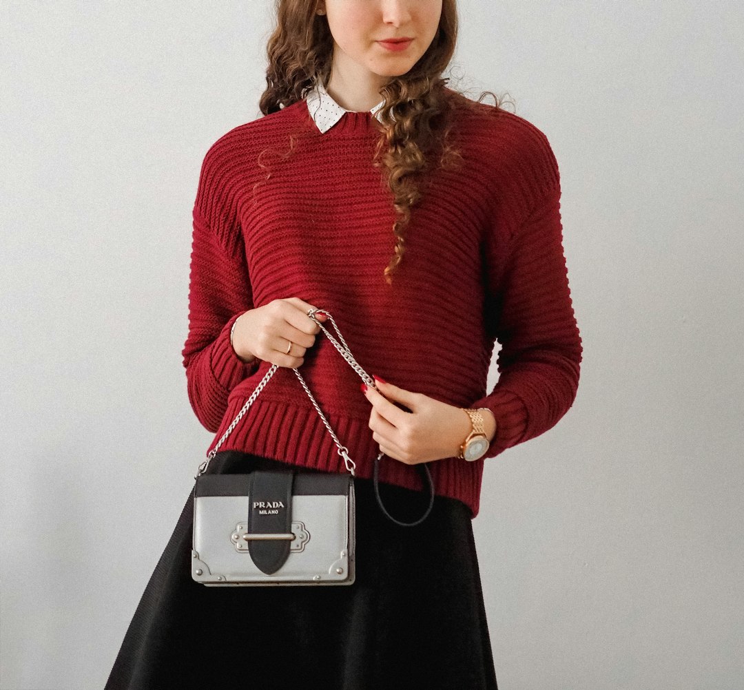 woman in red sweater holding white smartphone