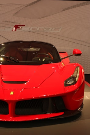Bright red sports car featuring a custom logo design on the hood