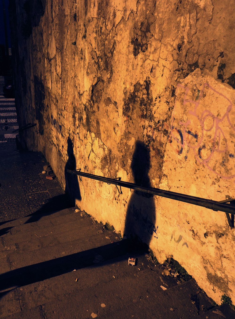 shadow of a person on a brown concrete wall