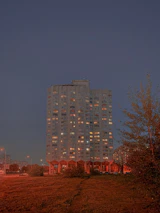 Finished residential building illuminated with yellow lights at dusk, showcasing quality construction.