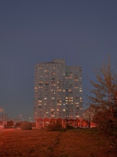 Luxurious modern high-rise residential building with elegant lighting at dusk.