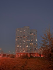 A sleek high-rise residential building glowing at dusk in Musaffah, Abu Dhabi.