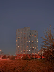A stately residential building at dusk, illuminated warmly, reflecting stability and care.