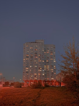 A sleek high-rise residential building glowing at dusk in Musaffah, Abu Dhabi.