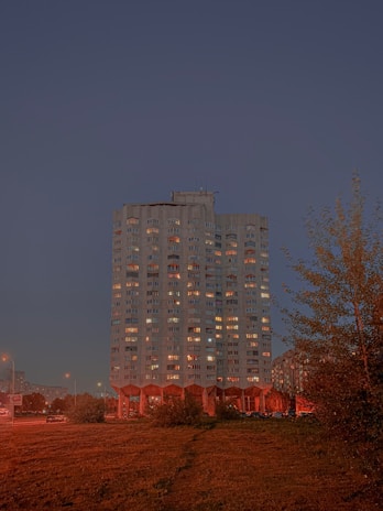 Luxurious modern high-rise residential building with elegant lighting at dusk.
