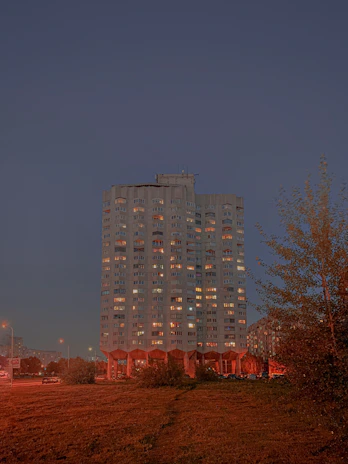 A well-maintained residential building at dusk, warmly lit and inviting.