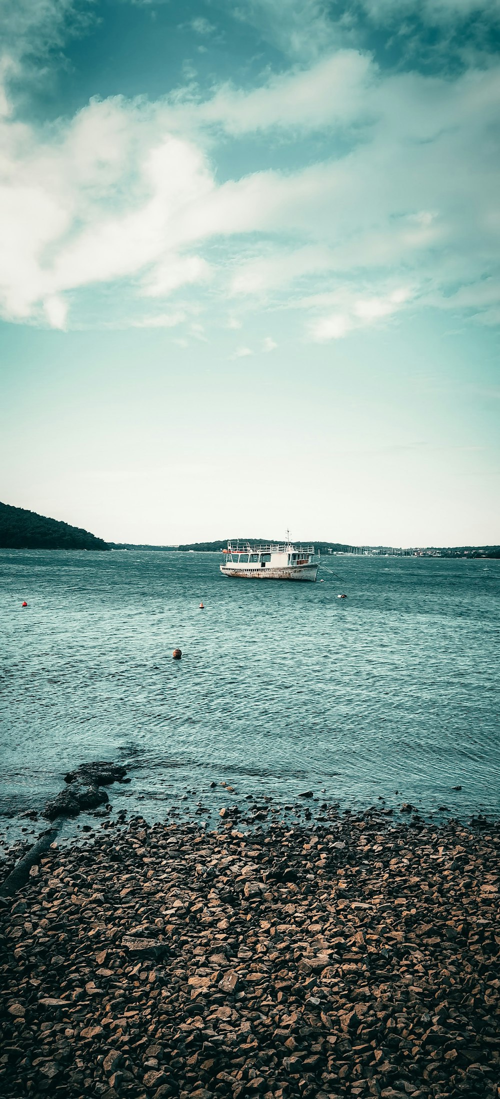 white boat on sea under white sky during daytime