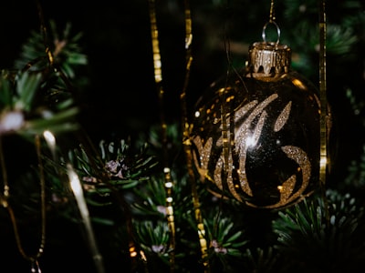 gold and black bauble on green christmas tree joyeux noel zoom background