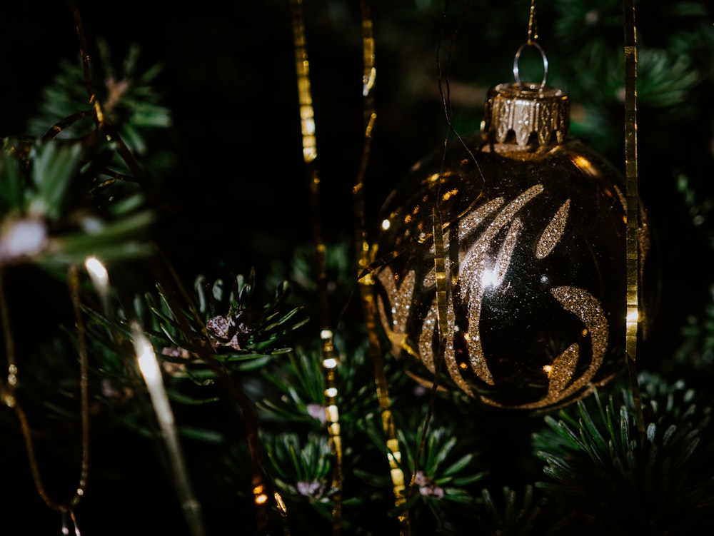 gold and black bauble on green christmas tree