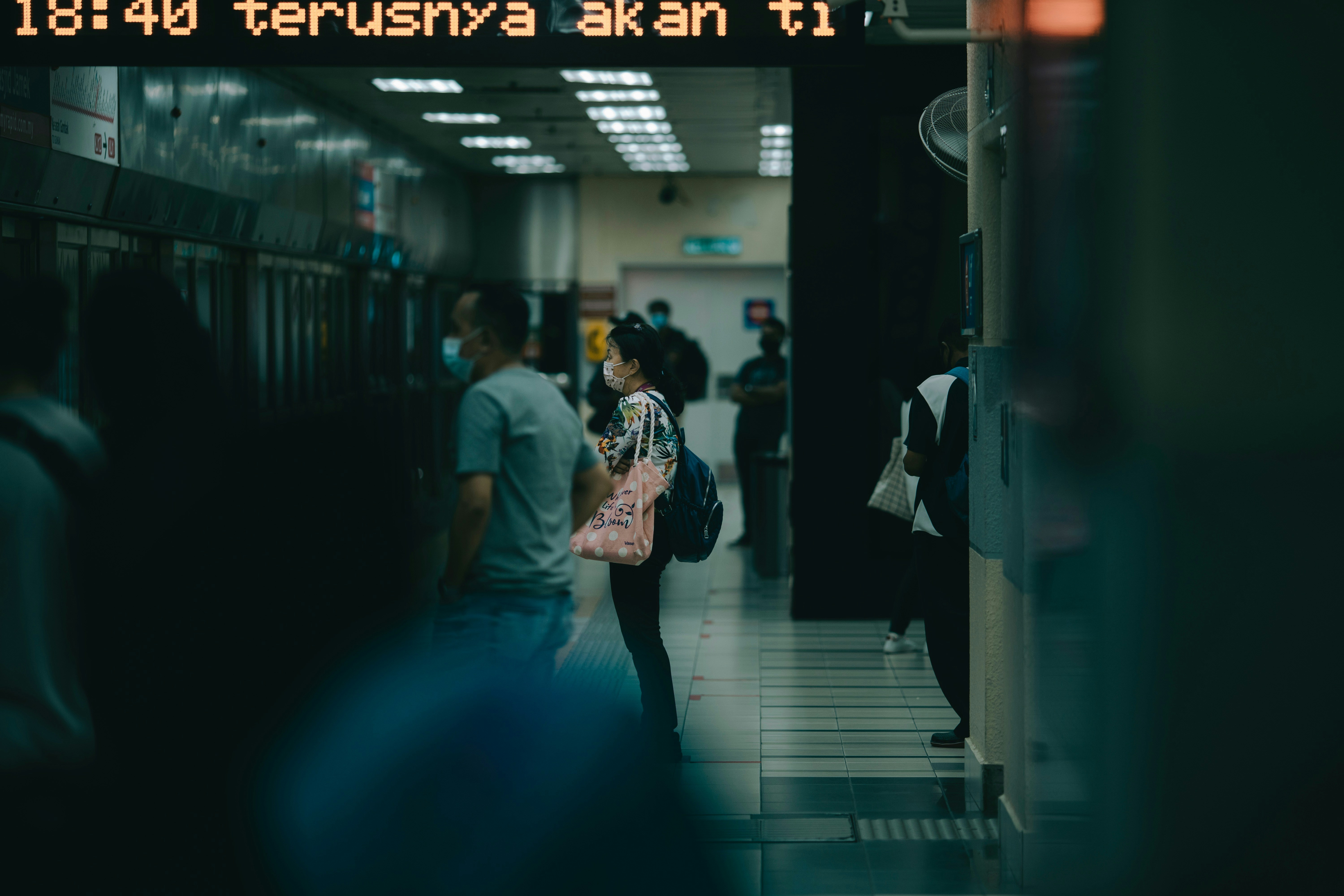 Mann in grauem T-Shirt geht auf Bürgersteig