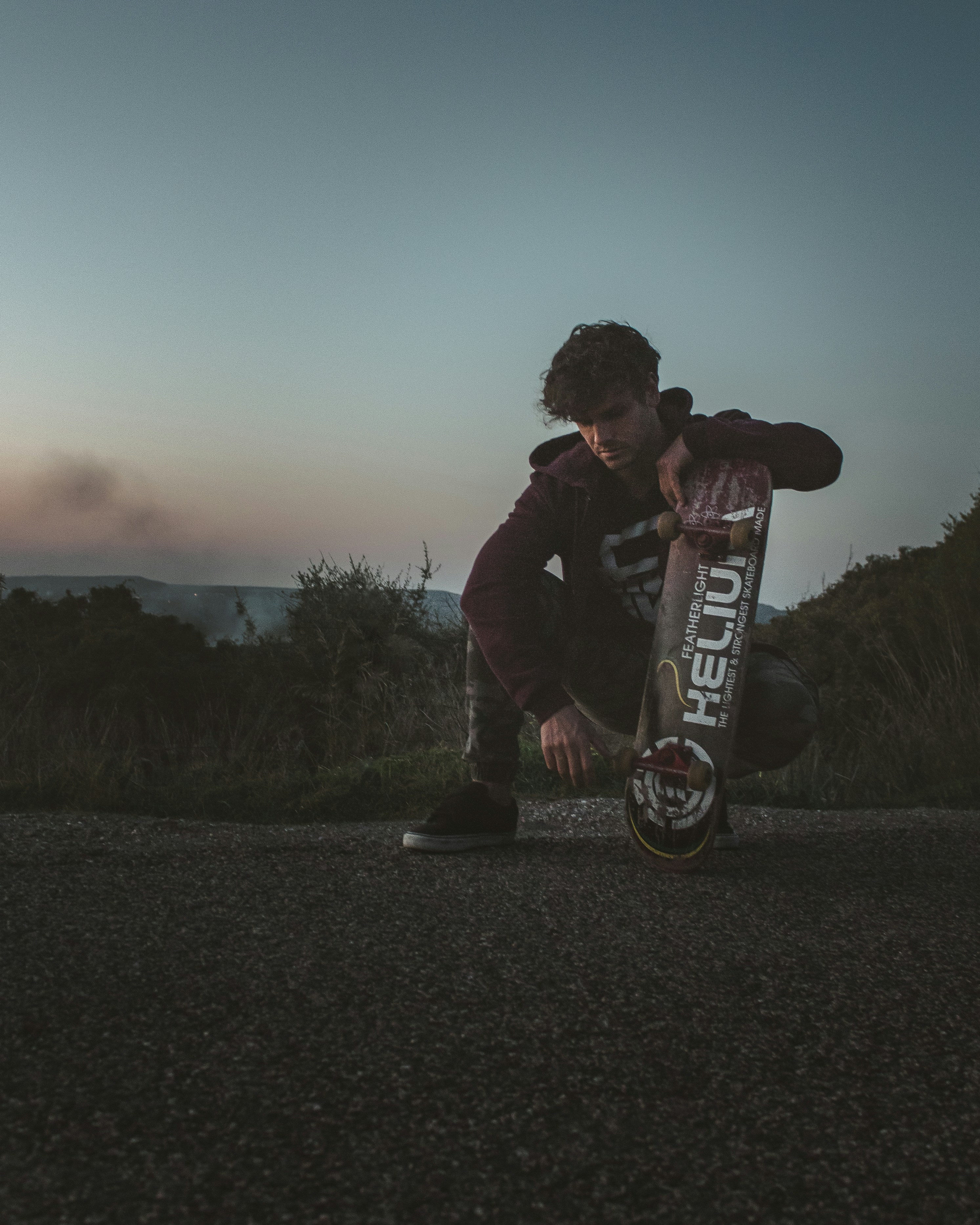 a man kneeling down with a skateboard in his hands