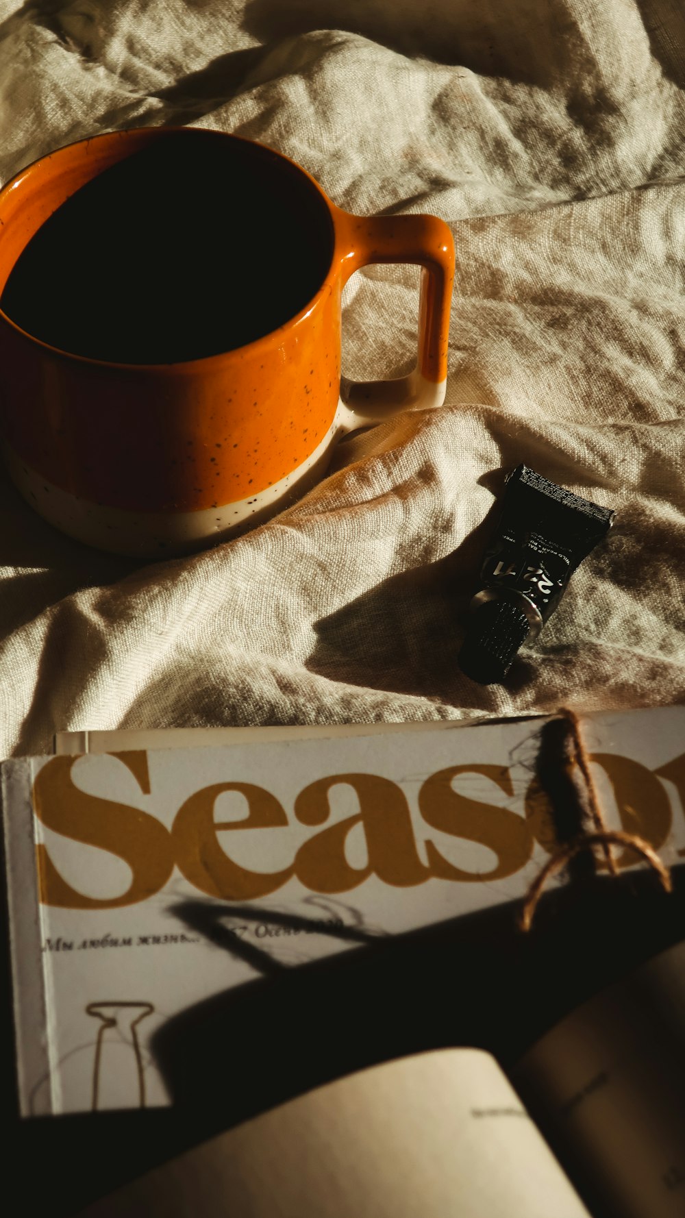 brown ceramic mug on white textile