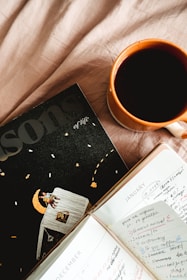 A calm morning scene with a cup of coffee, a phone showing a motivational course, and a journal.