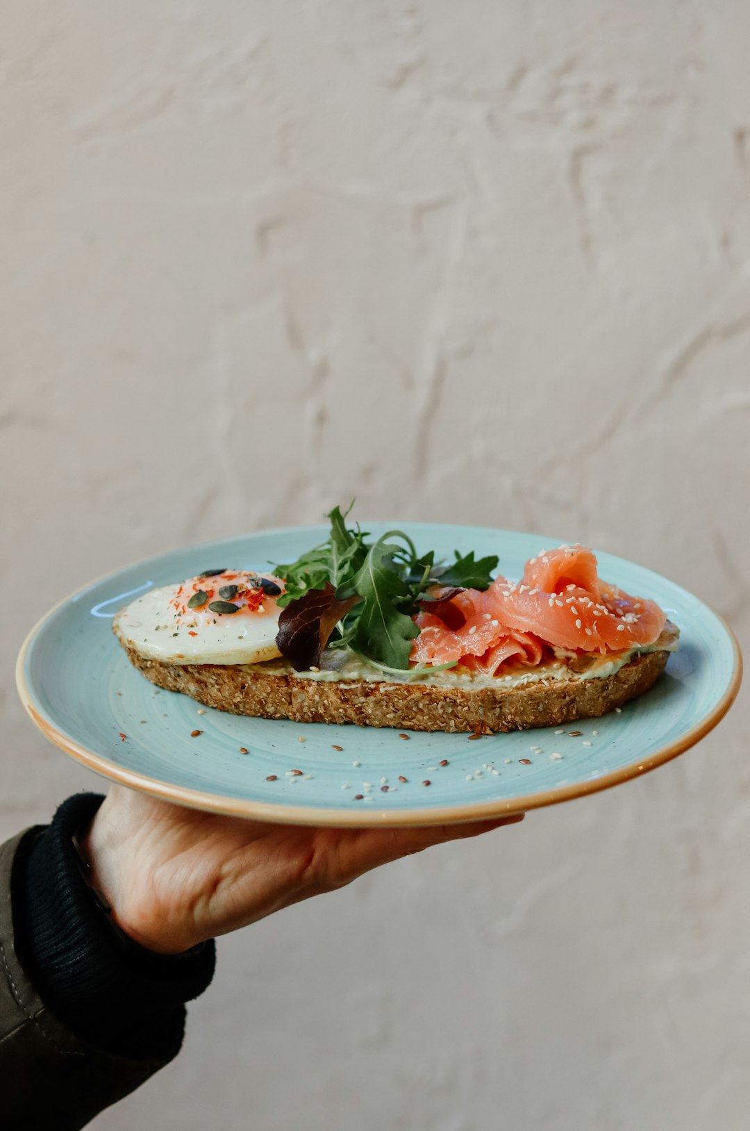 person holding white ceramic plate with food