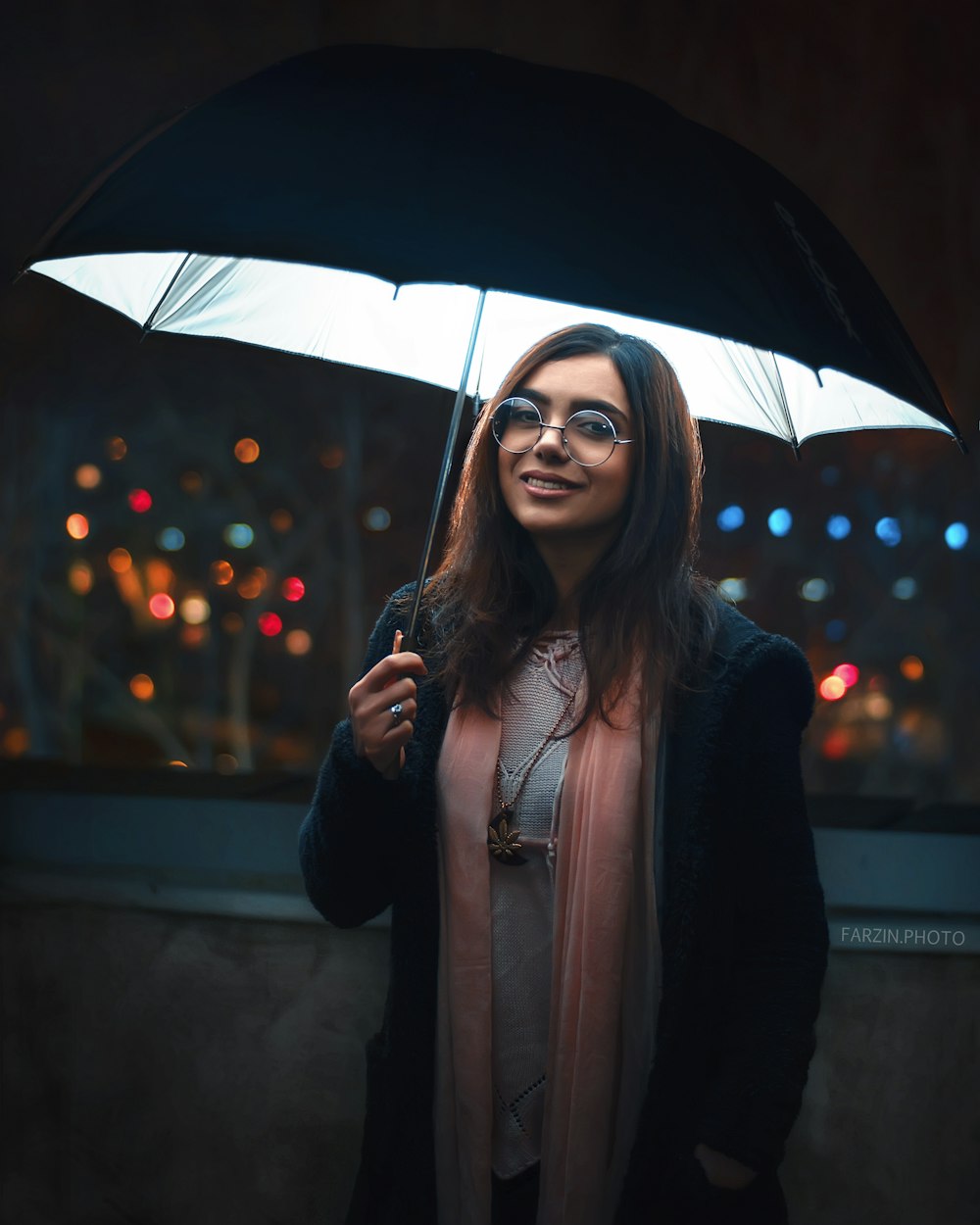 woman in black coat holding umbrella